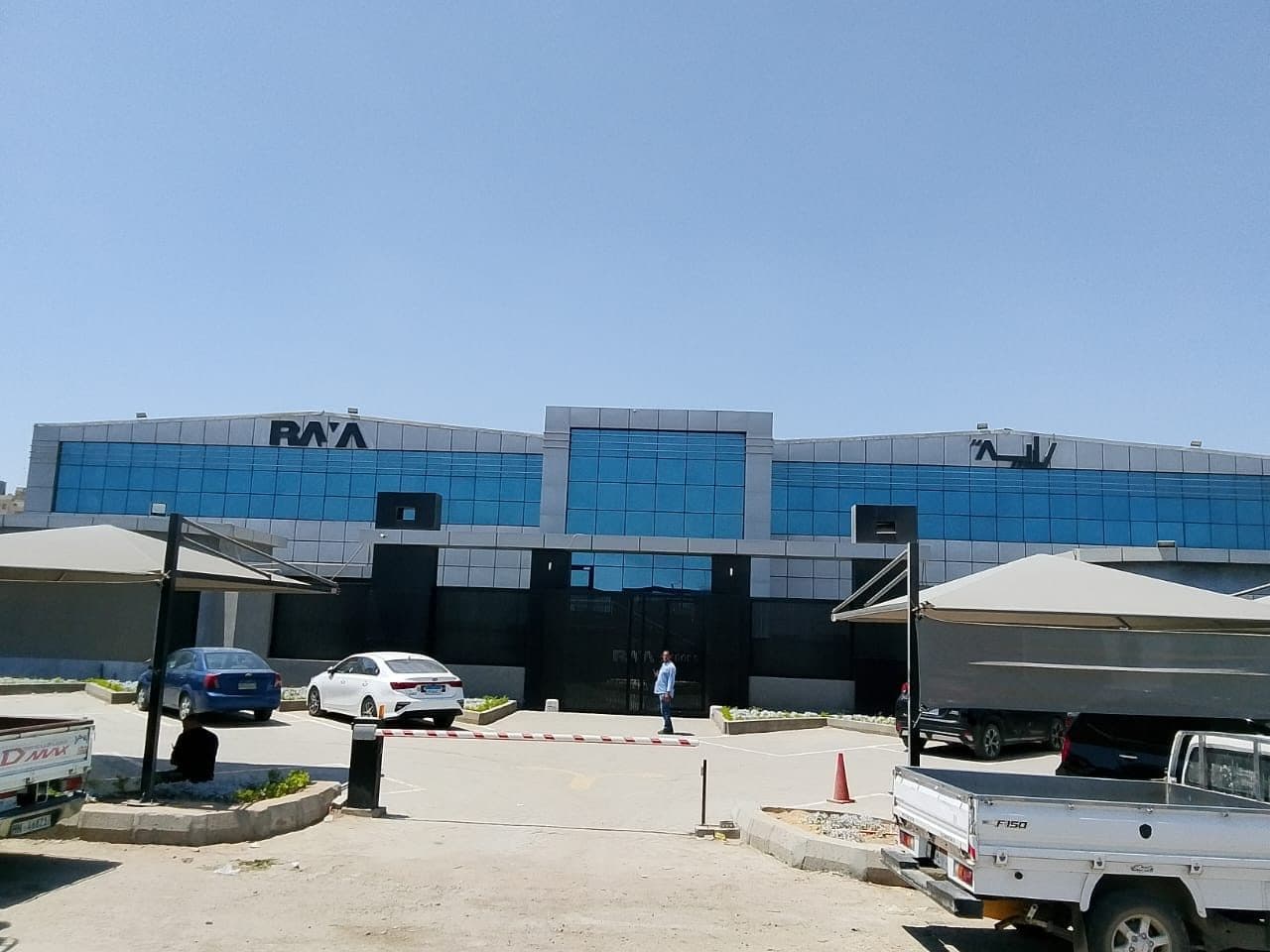 Completed food manufacturing complex — main frontage with curtain walling, gatehouse and shaded parking.